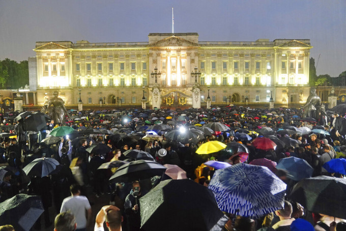 倫敦下著毛毛細雨，但眾人未有離開，反而舉起雨傘繼續留守悼念。AP圖片