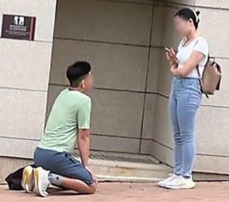 该名男子将背囊放在地上,向一名女子下跪。 该名男子将背囊放在地上,向一名女子下跪。