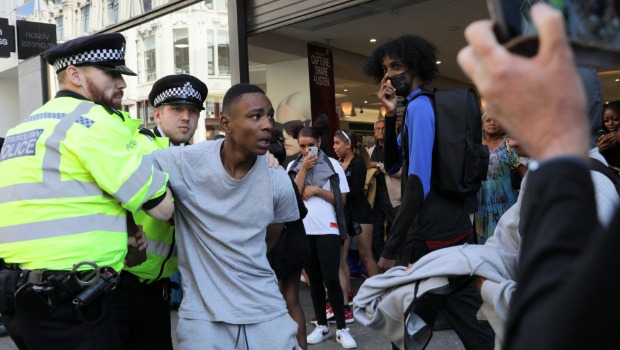 警察在街头抓捕抢店铺青年。 路透社 警察在街头抓捕抢店铺青年。 路透社