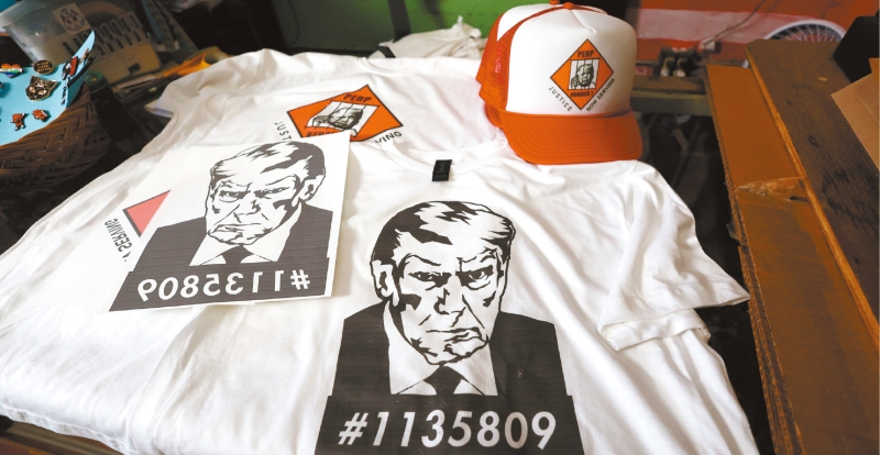前总统特朗普的大头照曝光后，选举阵营迅速大量印制T恤等商品，吸引民众购买筹款