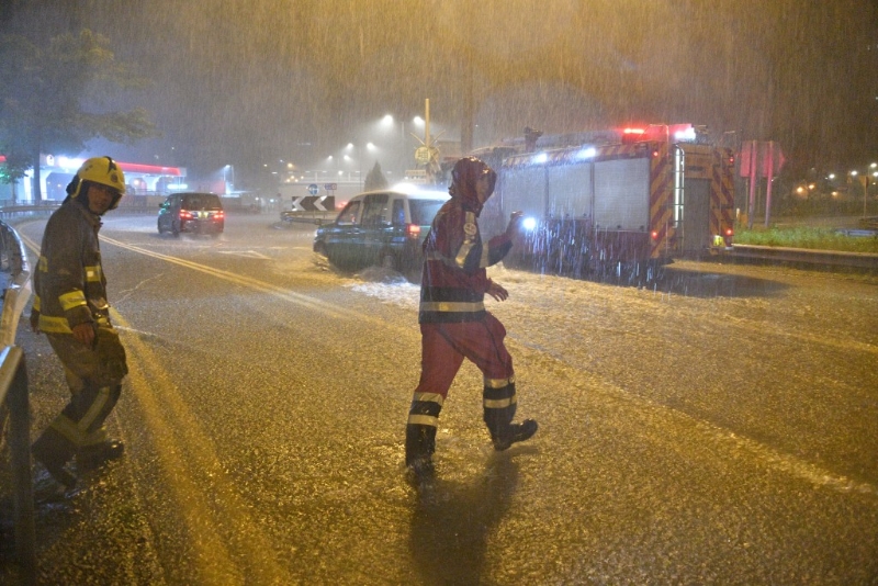 消防员冒着黑雨行动。 消防员冒着黑雨行动。