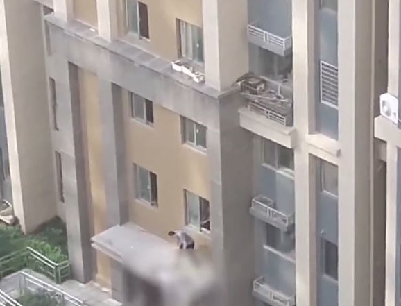 救援人员爬出房檐察看伤者情况。 救援人员爬出房檐察看伤者情况。