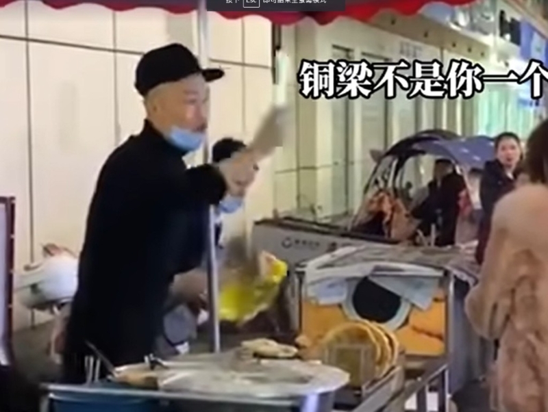 男档主起初站在摊档内与大妈理论。网图 男档主起初站在摊档内与大妈理论。网图