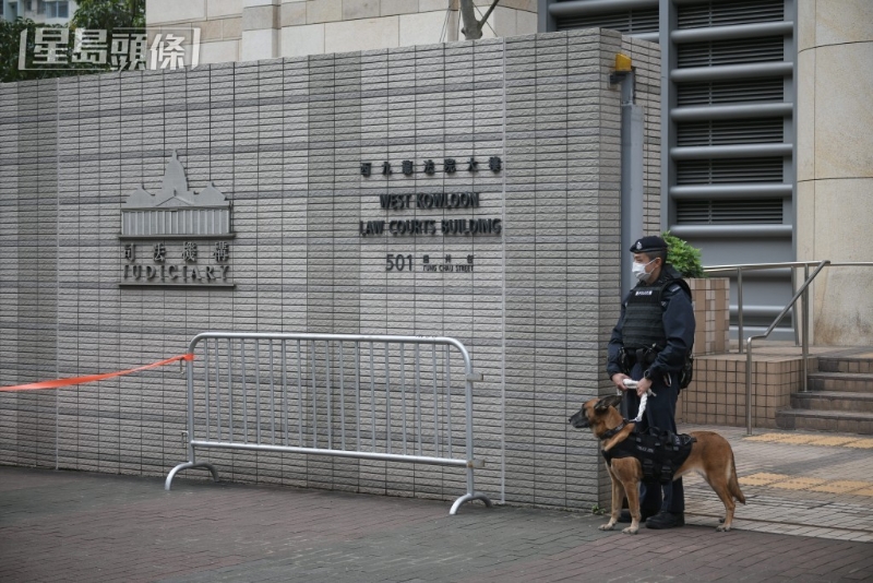 案件今早在西九龙裁判法院开审，警员携同警犬在门外站岗。