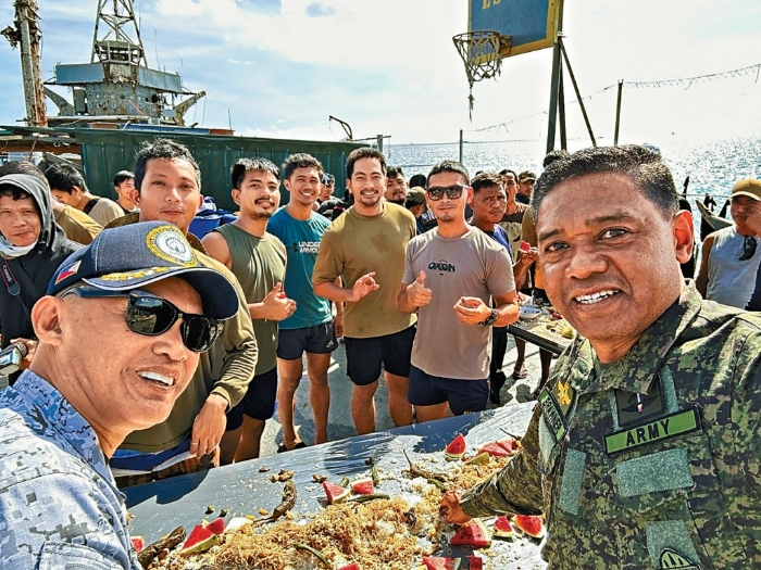 菲律宾总参谋长小布劳纳（右）登仁爱礁“坐滩”军舰，与海军人员共进晚餐。