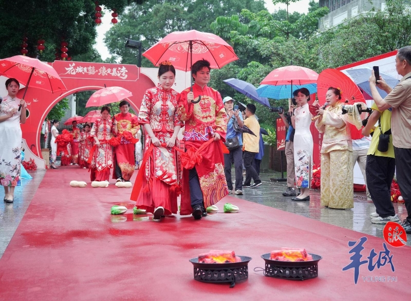 新郎撑着红伞，与新娘携手跨过寓意着人丁兴旺、身壮力强、生活圆满的花生、生菜、火盆，并缓缓走进婚礼主会场.jpg