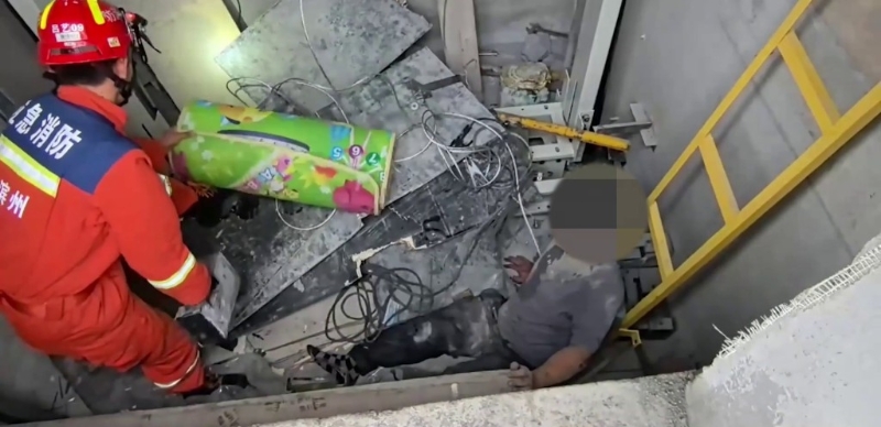 男子坐在升降机井底无法动弹。 男子坐在升降机井底无法动弹。