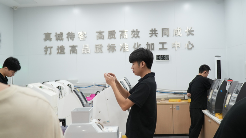 加工中心里认真打磨镜片的技工 加工中心里认真打磨镜片的技工