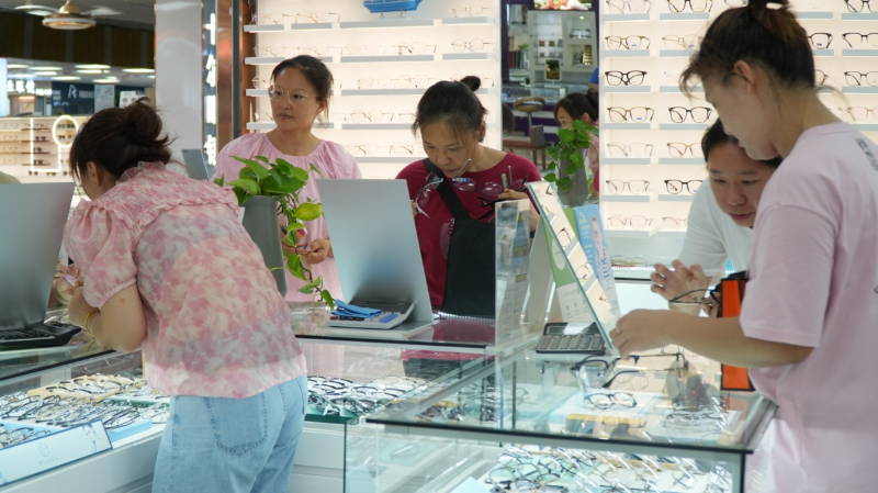 眼镜城里挑选眼镜的顾客 眼镜城里挑选眼镜的顾客