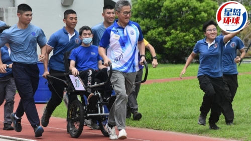 警务处处长萧泽颐参与“一起走过学堂的日子——轮椅人力车义工服务”活动，以特制的轮椅人力车接载受助人。 梁国峰摄