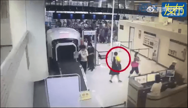 一名抱小孩女客神色紧张、举止异常,被海关截查。 一名抱小孩女客神色紧张、举止异常,被海关截查。