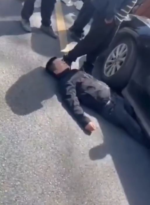 新娘兄长睡车底阻止婚车离开。影片截图 新娘兄长睡车底阻止婚车离开。影片截图