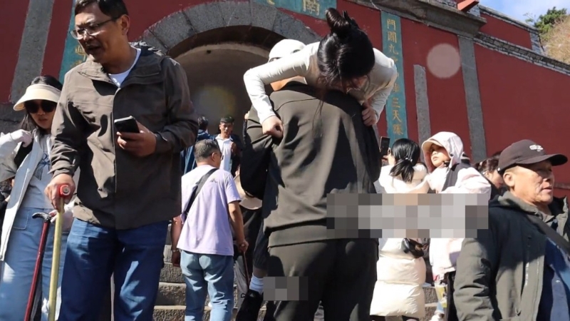 陪爬员一度抱起女网红登山。 陪爬员一度抱起女网红登山。