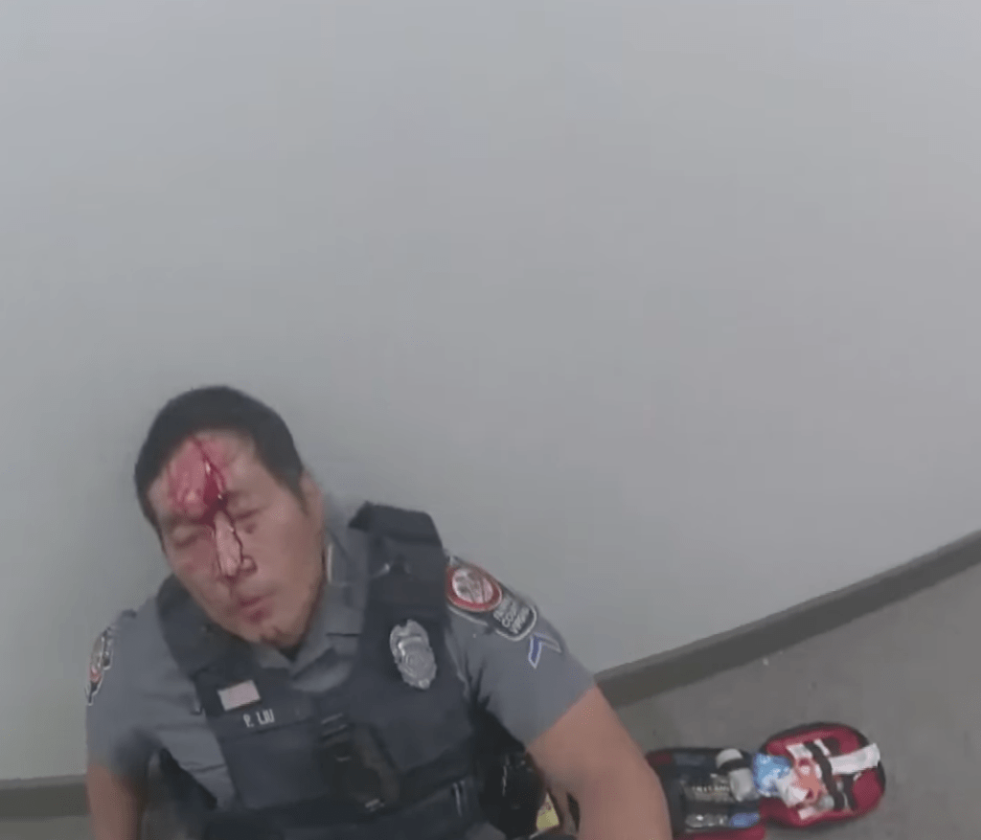 姓刘华裔警员向流披面倚在墙边。 姓刘华裔警员向流披面倚在墙边。