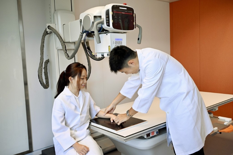 现年33岁的许文健(右)是东华学院今学年起开办的医疗影像学(荣誉)理学士课程其中一名学生。 现年33岁的许文健(右)是东华学院今学年起开办的医疗影像学(荣誉)理学士课程其中一名学生。