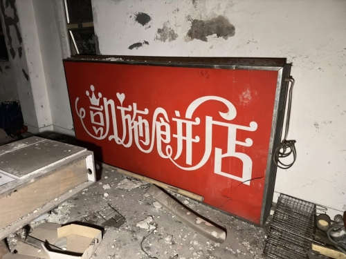 经典“红底”凯施饼店的照牌被放地上（图片：“穷游废墟”FB专页）