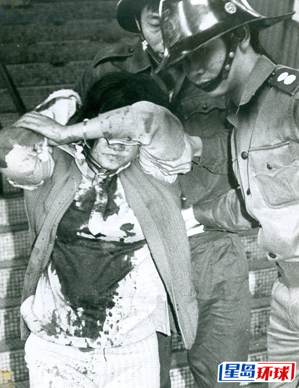 1973年,鲗鱼涌英皇道福昌大楼,一名男子因借钱不遂,杀害一名朋友及在该单位放火,疑凶陈梓梁(又名陈仲文及黄志恒,亦疑为澳门八仙饭店十人命案疑凶)。图为福昌楼劫杀案,其中一名女伤者被救出。 1973年,鲗鱼涌英皇道福昌大楼,一名男子因借钱不遂,杀害一名朋友及在该单位放火,疑凶陈梓梁(又名陈仲文及黄志恒,亦疑为澳门八仙饭店十人命案疑凶)。图为福昌楼劫杀案,其中一名女伤者被救出。