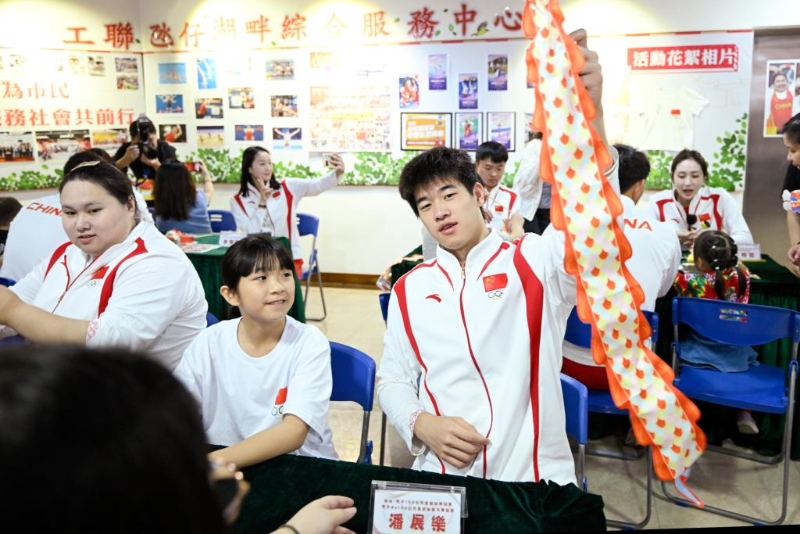 9月2日,在澳门工联氹仔湖畔综合服务中心,游泳运动员潘展乐(右)展示与小朋友一起制作的灯笼。新华社发 9月2日,在澳门工联氹仔湖畔综合服务中心,游泳运动员潘展乐(右)展示与小朋友一起制作的灯笼。新华社发