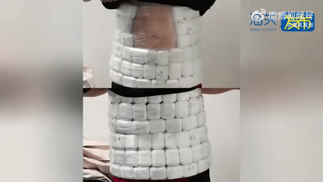 男子用保鲜纸在腰间藏有百部无线耳机。 男子用保鲜纸在腰间藏有百部无线耳机。