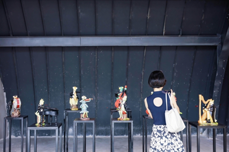 Tourists taking photos of Shiwan ceramic artworks. Tourists taking photos of Shiwan ceramic artworks.