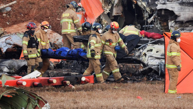 搜救人员从飞机残骸抬出乘客遗体。 搜救人员从飞机残骸抬出乘客遗体。