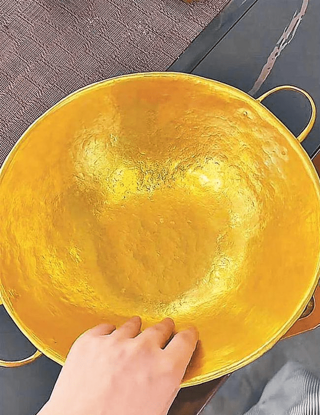 黄金锅两个把手是另外打制,穿孔之后再敲打,装到圆锅两侧。 黄金锅两个把手是另外打制,穿孔之后再敲打,装到圆锅两侧。