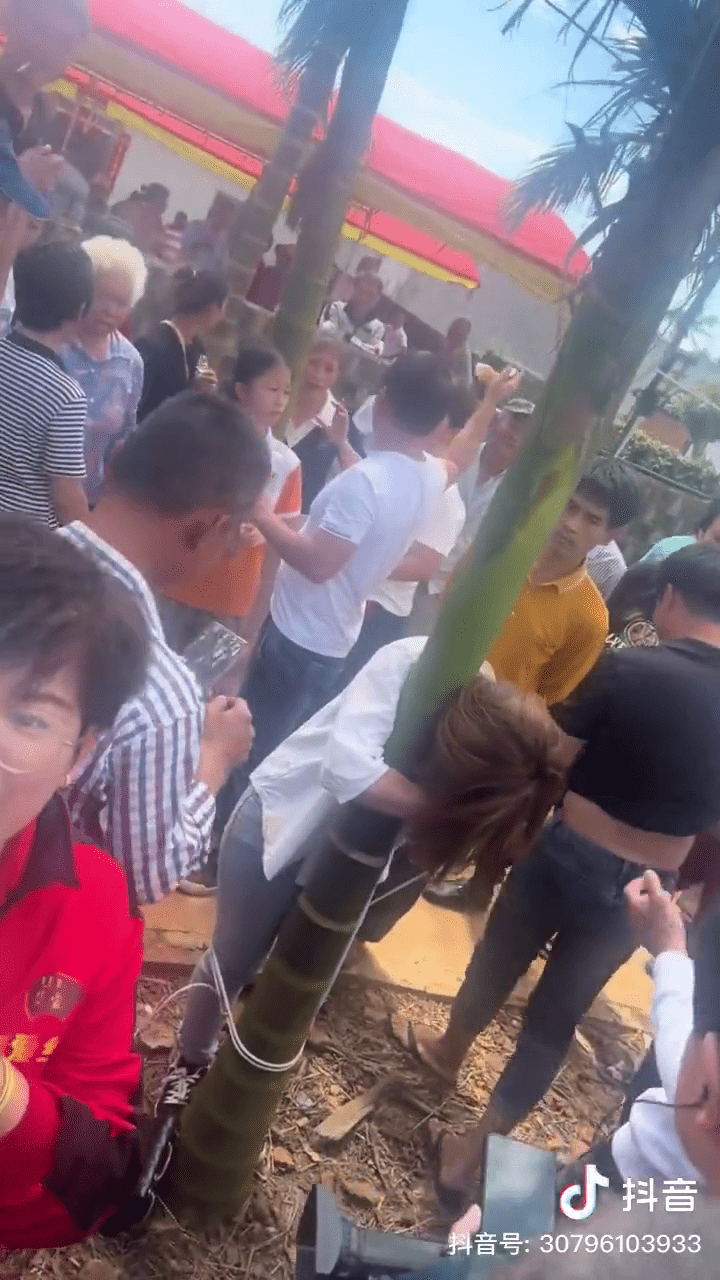 女疑犯被村民抓了回来,绑在树上。 女疑犯被村民抓了回来,绑在树上。