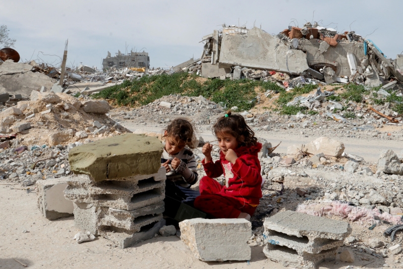 2025年3月13日,巴勒斯坦儿童坐在拉法遭到毁坏坍塌的房屋中。路透社 2025年3月13日,巴勒斯坦儿童坐在拉法遭到毁坏坍塌的房屋中。路透社