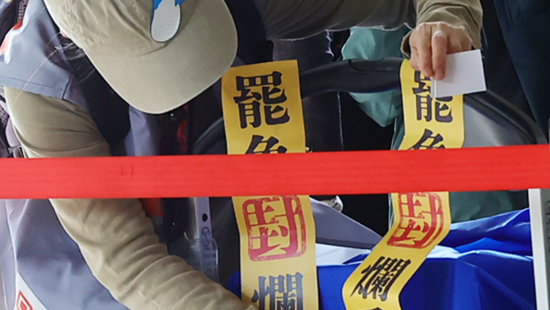 图为罢免团体工作人员在载运资料的推车上贴著罢免烂委的封条 图为罢免团体工作人员在载运资料的推车上贴著罢免烂委的封条