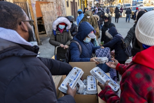 在纽约哈林区,Abou Sow 向排队的人们发放FarmerJawn Agriculture 提供的免费鸡蛋。 美联社 在纽约哈林区,Abou Sow 向排队的人们发放FarmerJawn Agriculture 提供的免费鸡蛋。 美联社