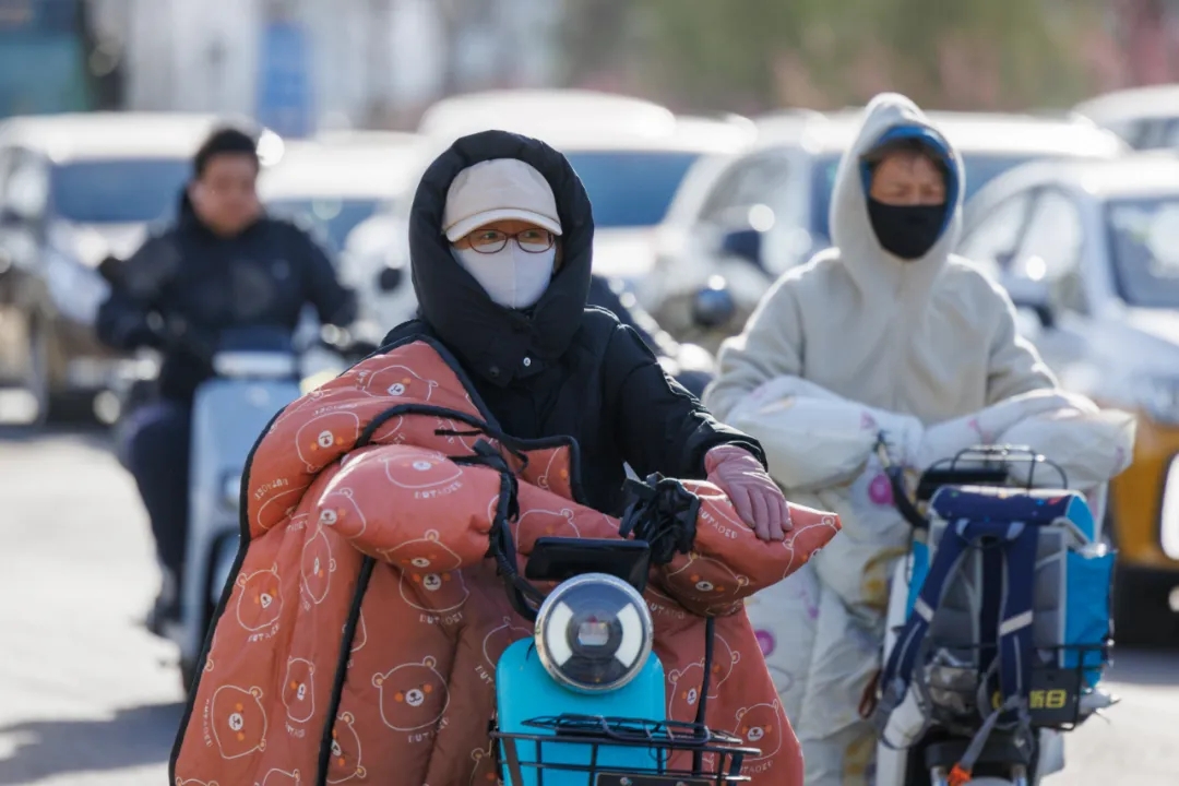 骑行市民穿着厚衣物挡风。 骑行市民穿着厚衣物挡风。