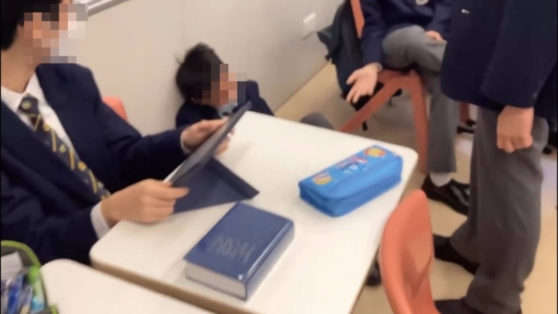 被袭学生瑟缩地上。 被袭学生瑟缩地上。