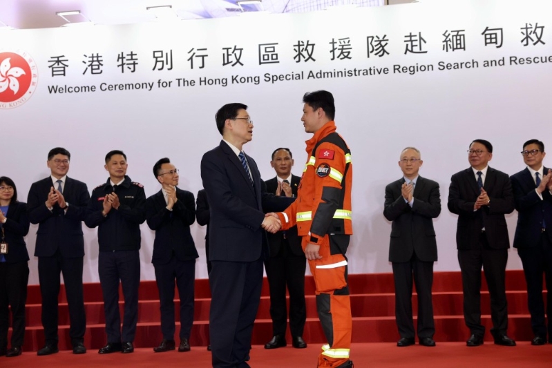 李家超与救援队队员握手。 李家超与救援队队员握手。