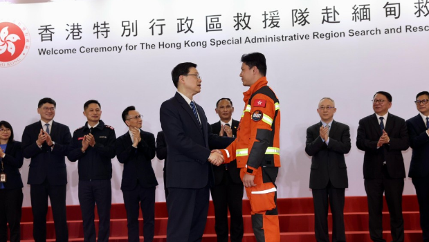 李家超与救援队队员握手。 李家超与救援队队员握手。