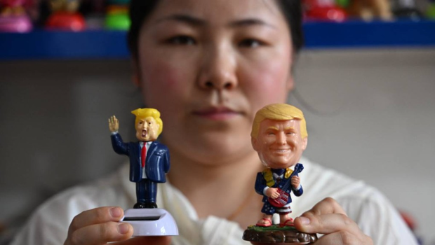 浙江义乌一名女售货员展示当地生产的特朗普玩偶。法新社 浙江义乌一名女售货员展示当地生产的特朗普玩偶。法新社