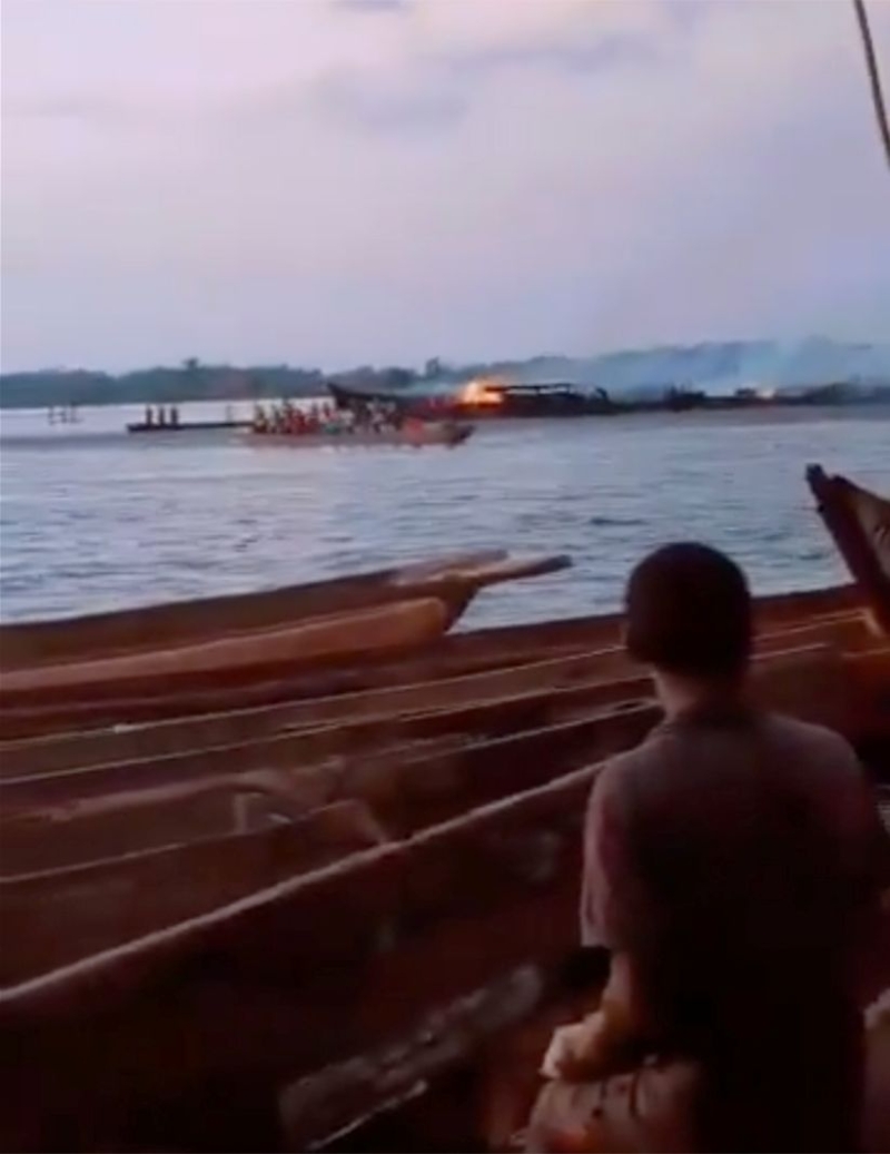 民众在岸上目睹木船着火。 民众在岸上目睹木船着火。