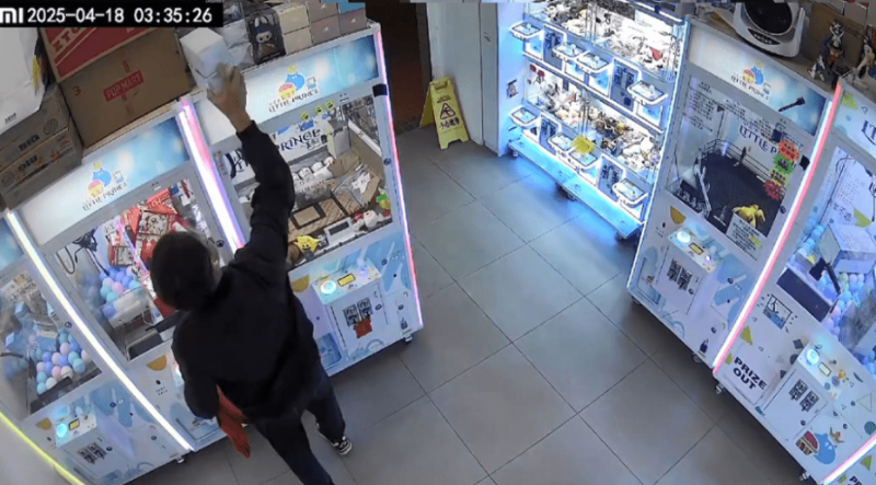 男子在其中一部夾公仔機頂部取下兩盒玩具並放入紙袋。fb「上水,粉嶺,大埔分享群」片段截圖