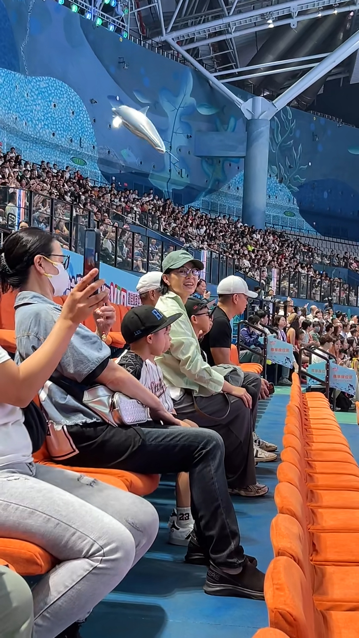 胡杏兒頭戴綠色Cap帽及身穿淺綠色襯衫,與家人一起坐在VIP區域觀看演出,她臉上掛滿笑容,時不時還揮手互動,看起來心情大好。