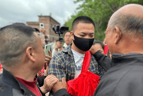 「梅姨案」被拐兒童鍾彬21年後身披大紅花回家。