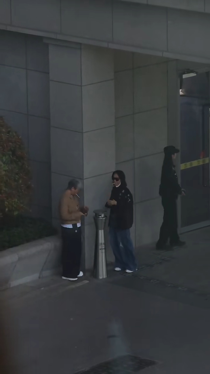 惠英红同一地方再次抽烟,身旁多了一位打扮中性的女士。 惠英红同一地方再次抽烟,身旁多了一位打扮中性的女士。