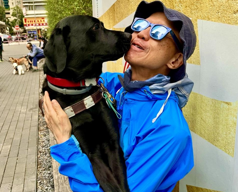 曾建平现由导盲犬Vinny引路。 曾建平现由导盲犬Vinny引路。