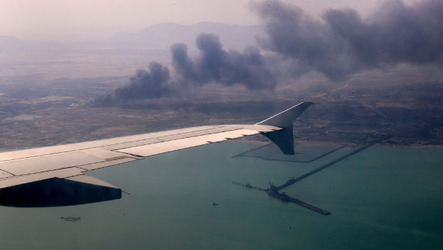 爆炸现场仍冒出滚滚黑烟,飘向海面。 爆炸现场仍冒出滚滚黑烟,飘向海面。