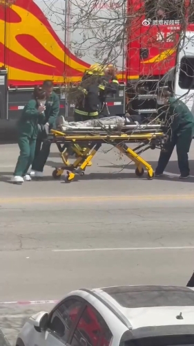 救护人员将伤者抬上救护车。 救护人员将伤者抬上救护车。