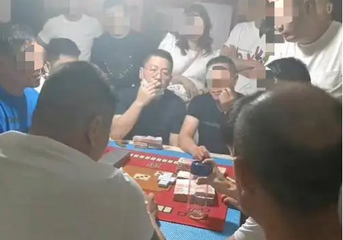 汤恕与人聚众赌博的视频截图,坐在中间戴着眼镜的抽烟男子为汤恕。 汤恕与人聚众赌博的视频截图,坐在中间戴着眼镜的抽烟男子为汤恕。