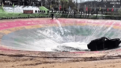 一旁还有一名男子不断往下灌水,另一人蹲下拿手机拍摄。 一旁还有一名男子不断往下灌水,另一人蹲下拿手机拍摄。