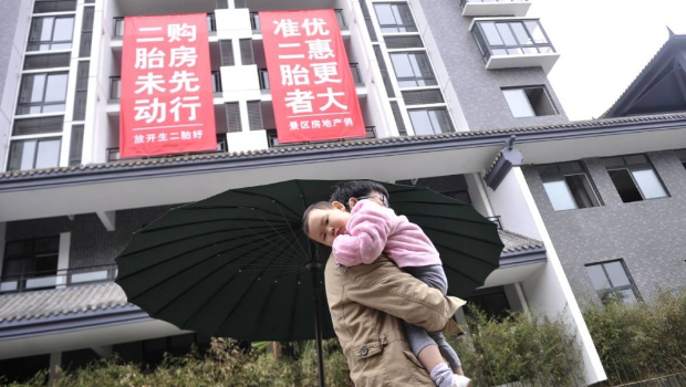 地产商挂横幅推出“生二胎”买楼优惠。中新社 地产商挂横幅推出“生二胎”买楼优惠。中新社