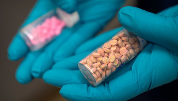 美国缉毒局高级法医化学家手持芬太尼药片小瓶。 美国缉毒局高级法医化学家手持芬太尼药片小瓶。