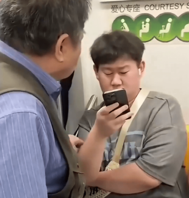 年轻人因坐在有“爱心专座”绿色标识的座位上,被老翁纠缠让座。 年轻人因坐在有“爱心专座”绿色标识的座位上,被老翁纠缠让座。