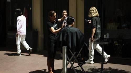 法国南部大停电,理发店光线不足,发型师和顾客移到大街上利用阳光剪发。 路透社 法国南部大停电,理发店光线不足,发型师和顾客移到大街上利用阳光剪发。 路透社