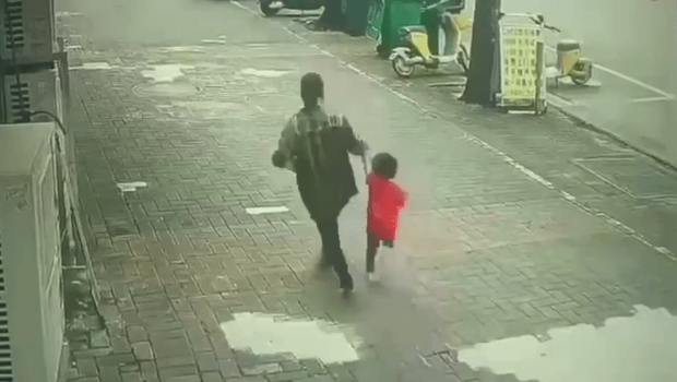 一名女子强行拖走一名小孩。 一名女子强行拖走一名小孩。